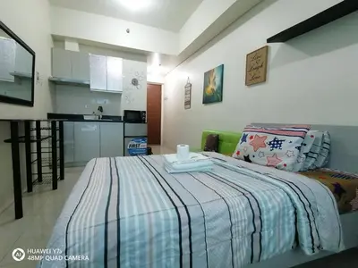 a bedroom with a bed with a blue and white blanket at The Beacon Makati Staycation Suites in Manila