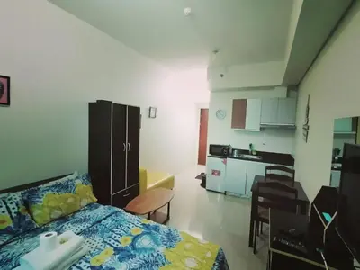 a small room with a bed and a kitchen at The Beacon Makati Staycation Suites in Manila