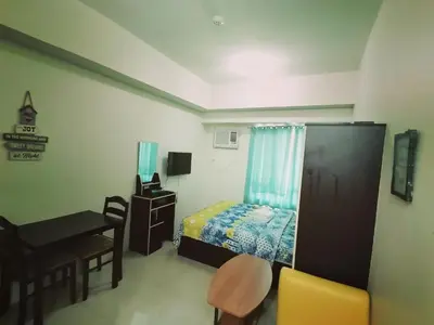 a bedroom with a bed and a table and a desk at The Beacon Makati Staycation Suites in Manila