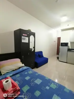 a small room with a bed and a kitchen at The Beacon Makati Staycation Suites in Manila