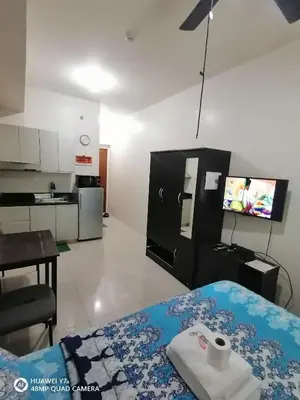 a hotel room with a bed and a kitchen at The Beacon Makati Staycation Suites in Manila