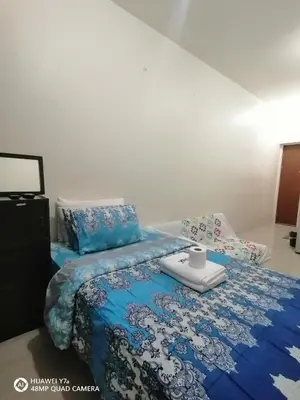 a bedroom with a bed with a blue comforter at The Beacon Makati Staycation Suites in Manila