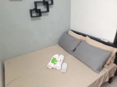 a bed with two white slippers on top of it at Flat NAIA Manila Chateau Elysee pool view in Manila