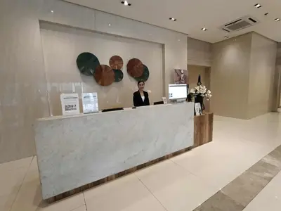 a woman standing at a counter in a lobby at Condotel Walking distance to Airport ( Terminal 3) in Manila