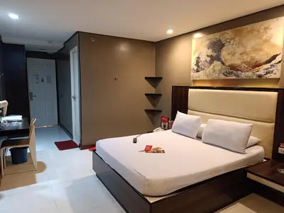 a bedroom with a bed and a desk in a room at Hotel Sogo Malate in Manila