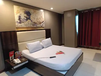a bedroom with a large bed with white sheets at Hotel Sogo Malate in Manila