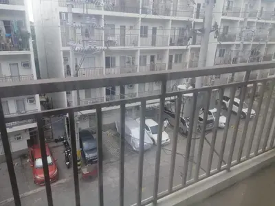 a balcony with cars parked in front of a building at Kassel Dorz Hostel in Manila