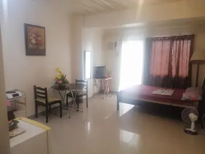 a living room with a bed and a table and chairs at Kassel Dorz Hostel in Manila