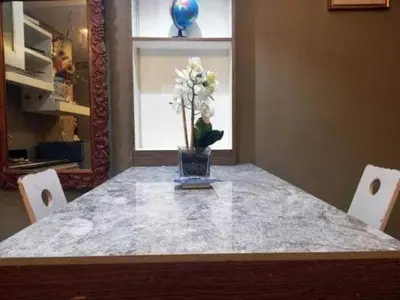 a table with a vase with white flowers on it at Kassel Dorz Hostel in Manila