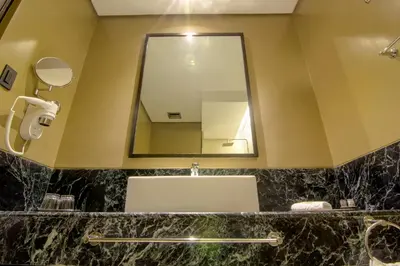 a bathroom with a sink and a mirror at 1898 Hotel Colonia En Las Filipinas in Manila