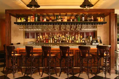 a bar with black stools in front of a bar at 1898 Hotel Colonia En Las Filipinas in Manila
