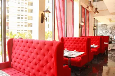 a restaurant with red seats and a table in front of a window at 1898 Hotel Colonia En Las Filipinas in Manila