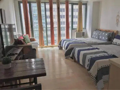 a hotel room with two beds and a couch at GREENFIELD studio w/ 2 queen across Shangrila in Manila