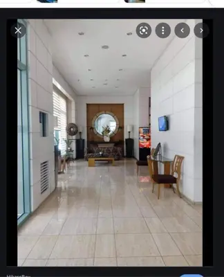 a large room with a lobby with a table and chairs at GREENFIELD studio w/ 2 queen across Shangrila in Manila