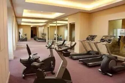 a gym with rows of treadmills and elliptical machines at GREENFIELD studio w/ 2 queen across Shangrila in Manila
