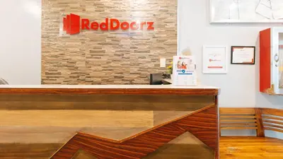 a red door sign on a brick wall at RedDoorz near Bambang Station in Manila