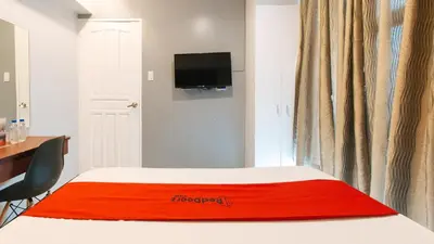 a hotel room with a red blanket on a bed at RedDoorz near Bambang Station in Manila