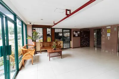 a lobby with a table and chairs and windows at RedDoorz at Moonwalk Paranaque in Manila