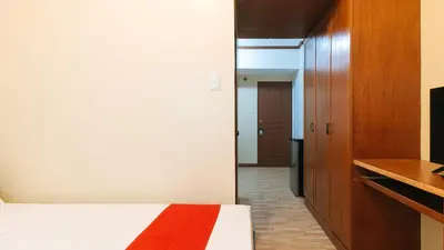 a bedroom with a bed and a tv and a hallway at RedDoorz at Moonwalk Paranaque in Manila