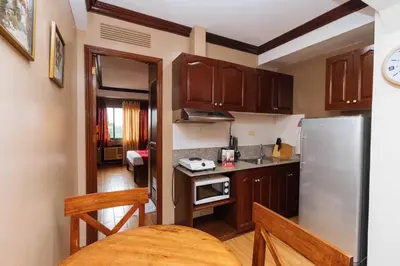 a small kitchen with a refrigerator and a table at RedDoorz at Moonwalk Paranaque in Manila