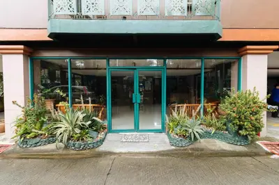 a store front with blue doors and potted plants outside at RedDoorz at Moonwalk Paranaque in Manila
