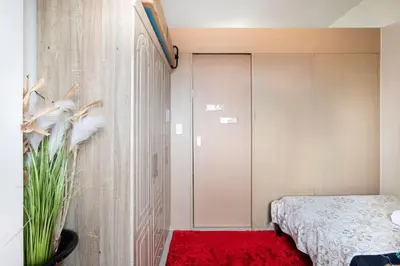 a bedroom with a bed and a red rug at Affordable condotel near Manila Airport in Manila