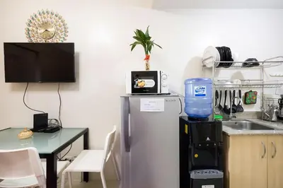 a kitchen with a small table and a refrigerator at Affordable condotel near Manila Airport in Manila