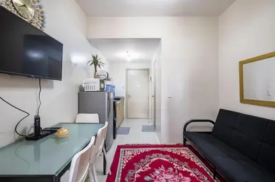 a living room with a black couch and a table at Affordable condotel near Manila Airport in Manila