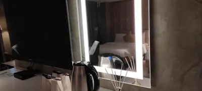 a mirror on a wall with a bed in a hotel room at City Park Hotel Residences in Manila