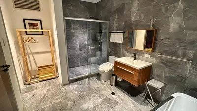 a bathroom with a shower and a sink and a toilet at City Park Hotel Residences in Manila