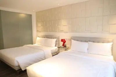 two beds sitting next to each other in a room at City Park Hotel Residences in Manila