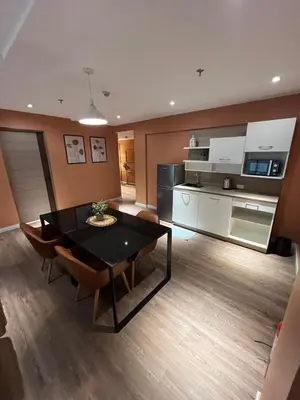 a living room with a dining room table and a kitchen at City Park Hotel Residences in Manila