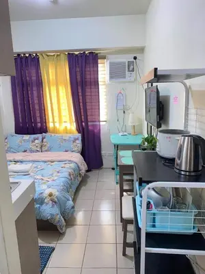 a small room with a bed and a table and a kitchen at Shanilyn Residency Urban Deca Towers EDSA mandaluyong UNLIMITED INTERNET AND NETFLIX in Manila