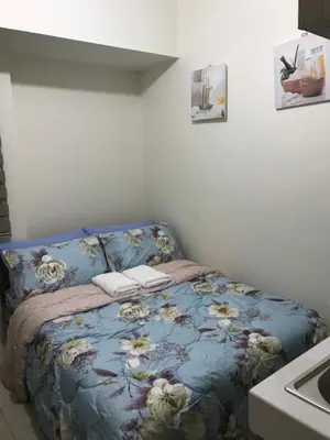 a bedroom with a bed with a blue comforter at Shanilyn Residency Urban Deca Towers EDSA mandaluyong UNLIMITED INTERNET AND NETFLIX in Manila