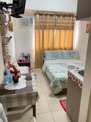a bedroom with a bed and a sink and a table at Shanilyn Residency Urban Deca Towers EDSA mandaluyong UNLIMITED INTERNET AND NETFLIX in Manila
