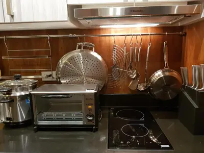 a kitchen counter with a toaster oven and utensils at Stay Amare Green La Salle Taft in Manila