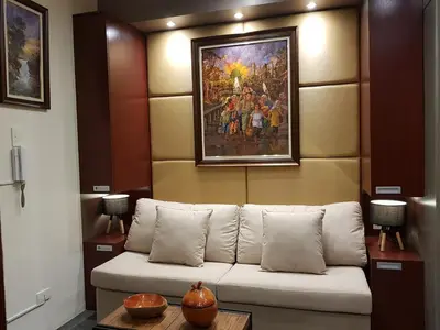 a couch in a room with a painting on the wall at Stay Amare Green La Salle Taft in Manila
