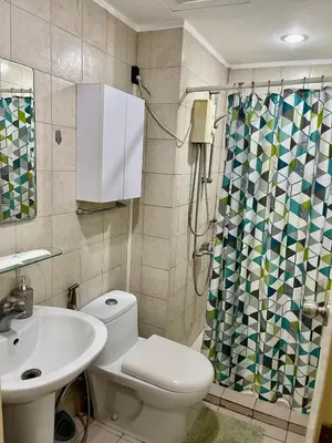 a bathroom with a toilet and a sink and a shower at Cozy Studio Unit in Soho central Private Residences in Manila