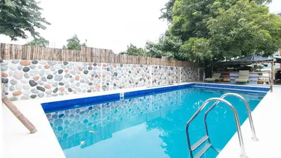 a swimming pool with a stone wall and a blue swimming pool at RedDoorz at DBuilders Rooms Lower Bicutan in Manila