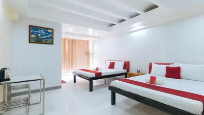a hotel room with two beds and a television at RedDoorz at DBuilders Rooms Lower Bicutan in Manila
