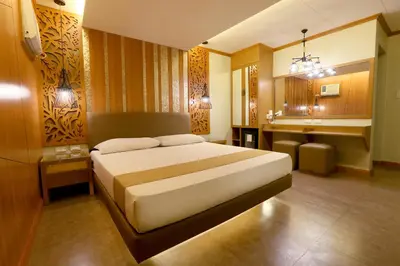 a bedroom with a large bed and a bathroom at Hotel Ava Cuneta in Manila
