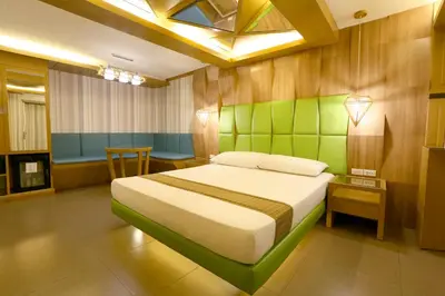 a bedroom with a bed with a green wall at Hotel Ava Cuneta in Manila