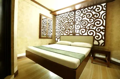 a bedroom with a bed with a black and white wall at Hotel Ava Gil Puyat in Manila