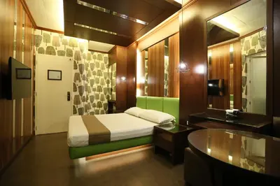 a bedroom with a bed and a desk and a sink at Hotel Ava Gil Puyat in Manila