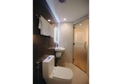 a bathroom with a toilet and a sink at Hotel Ava Gil Puyat in Manila