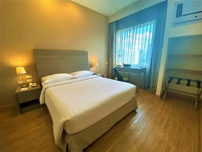 a bedroom with a large bed and a large window at One Pacific Place Serviced Residences in Manila
