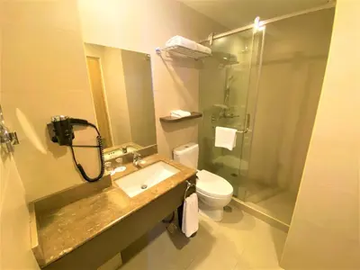 a bathroom with a sink and a toilet and a shower at One Pacific Place Serviced Residences in Manila