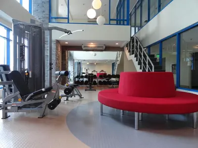 a gym with a red chair and gym equipment at One Pacific Place Serviced Residences in Manila