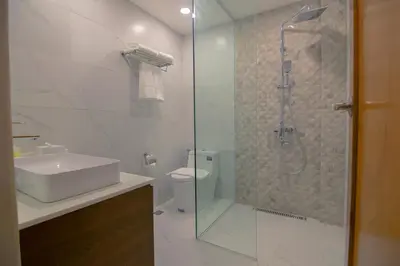 a bathroom with a shower and a sink and a toilet at Thunderbird Resorts - Rizal in Binangonan