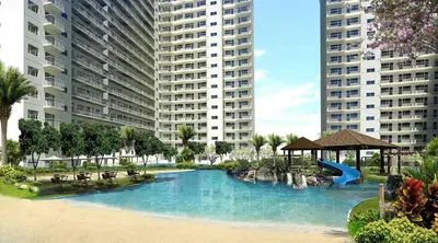 a swimming pool with a slide in a resort at Shore Residences MOA in Manila